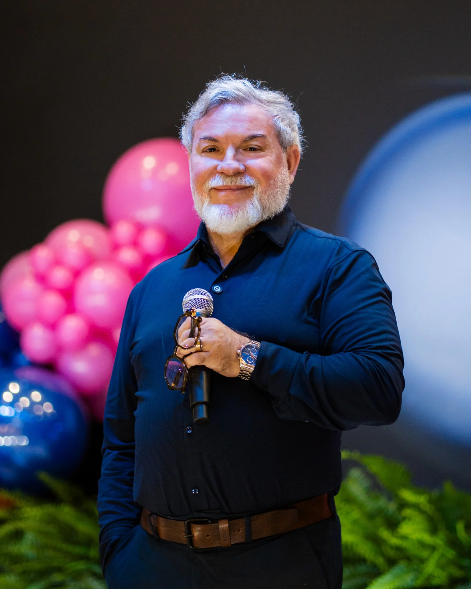 Prof. Claudio Romualdo segurando um microfone em um evento